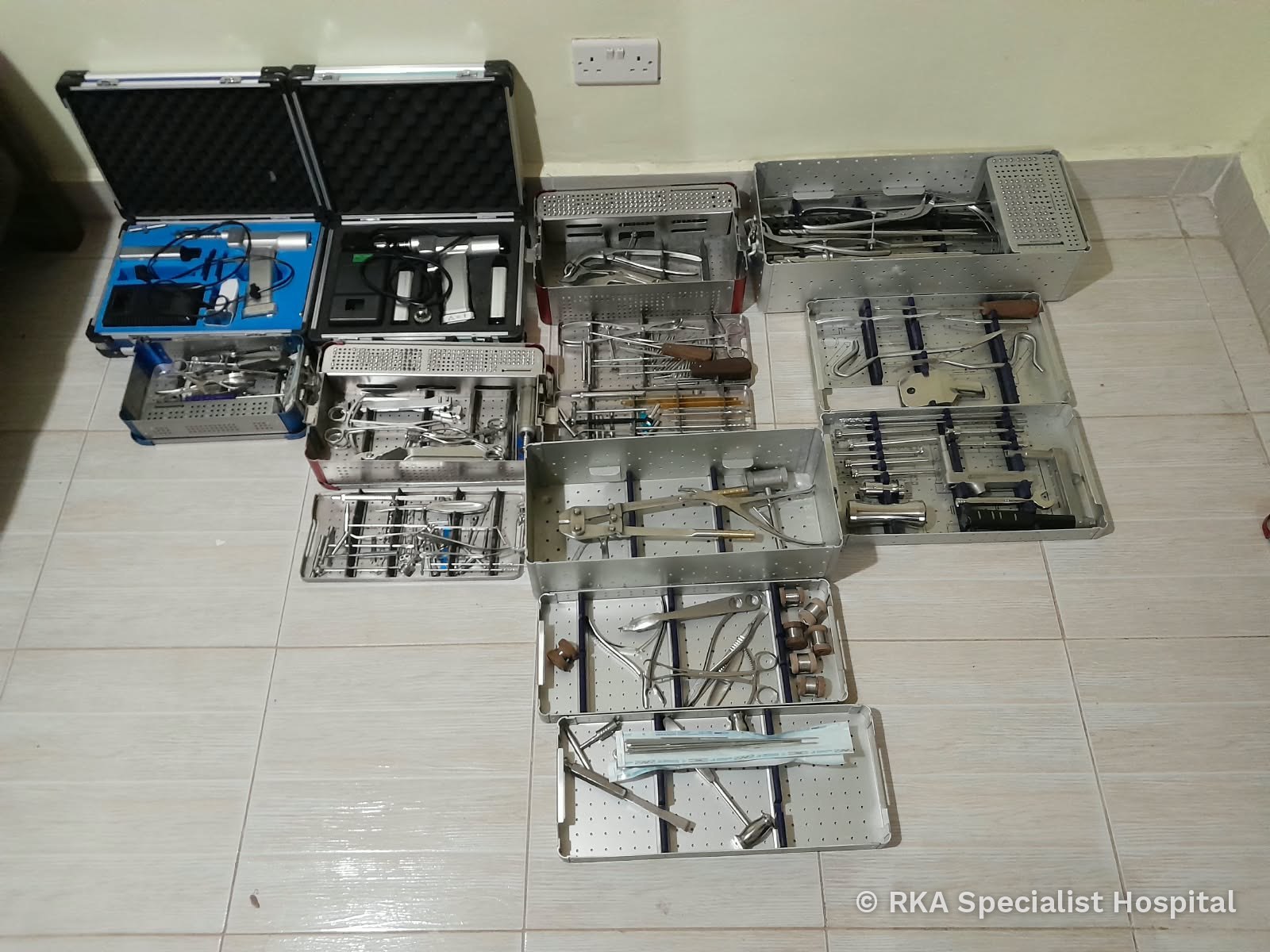 Orthopaedic instrument trays and power tool cases laid out for inspection